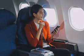 A girl sitting on the window seat in an airplane